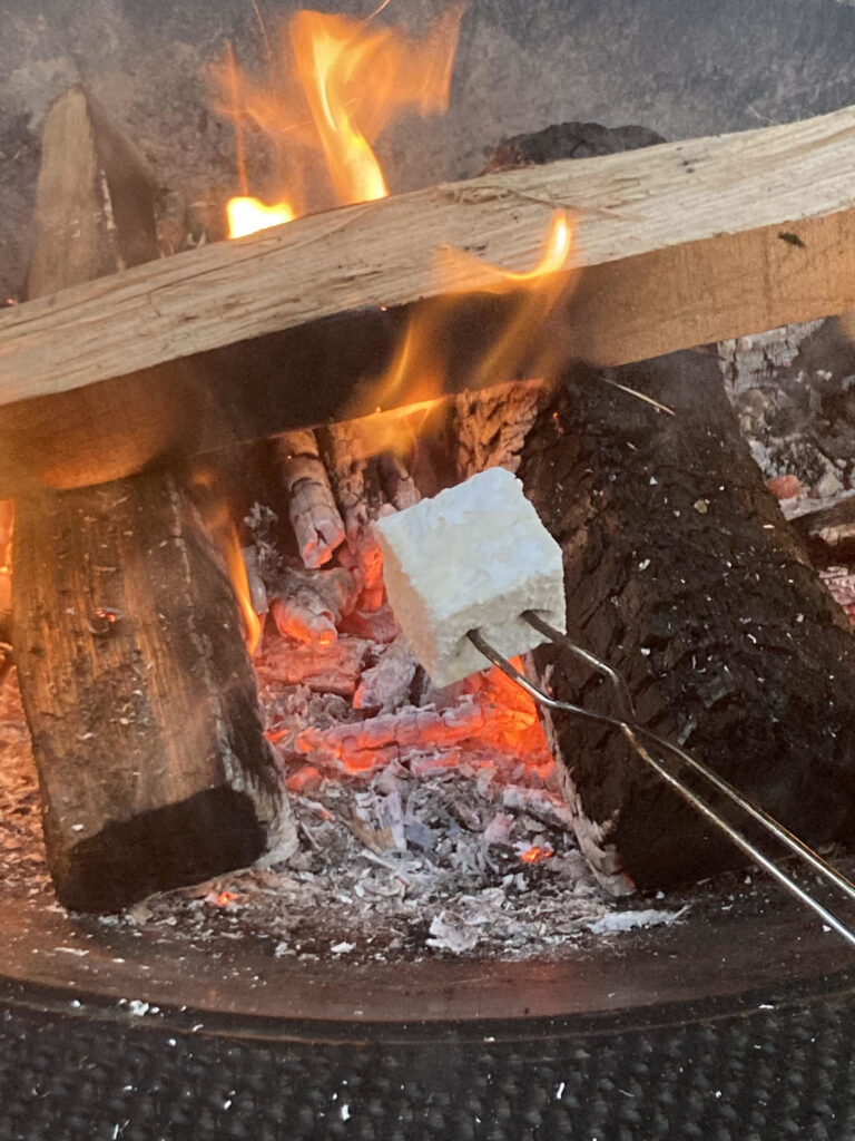 A marshmallow over a fire for a paleo camping meal