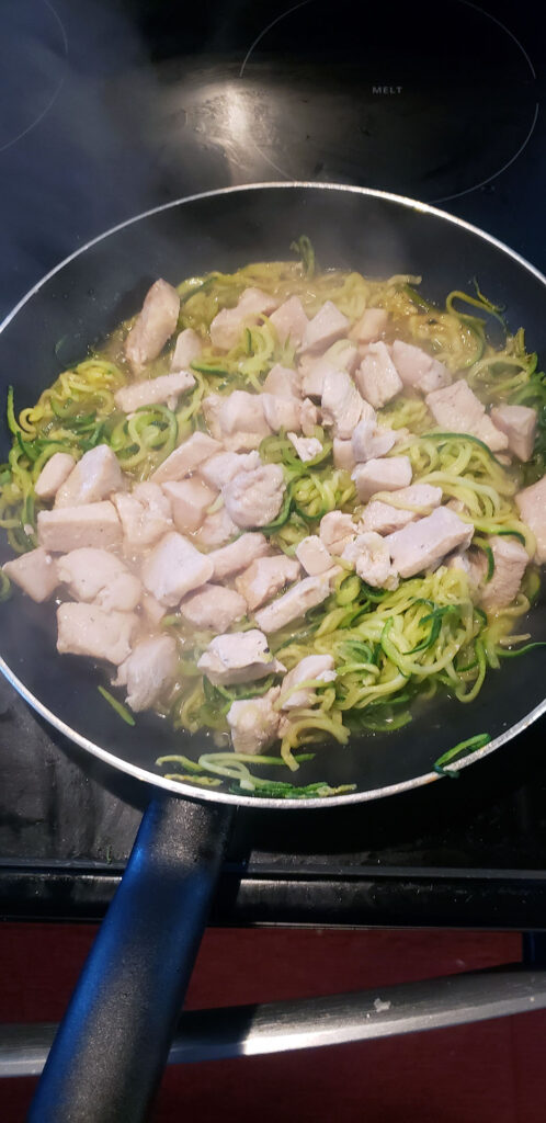 Chicken and zucchini noodles mixing together