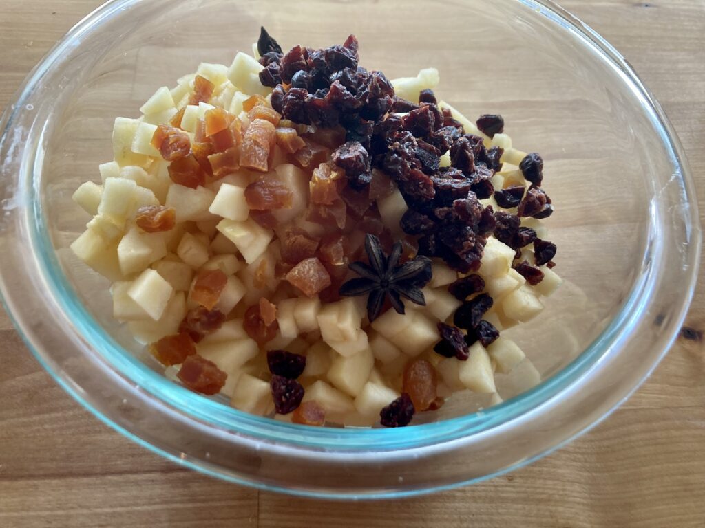 Apples, dried cranberries and apricots in a bowl ready to go on the stove for this apple chutney recipe.