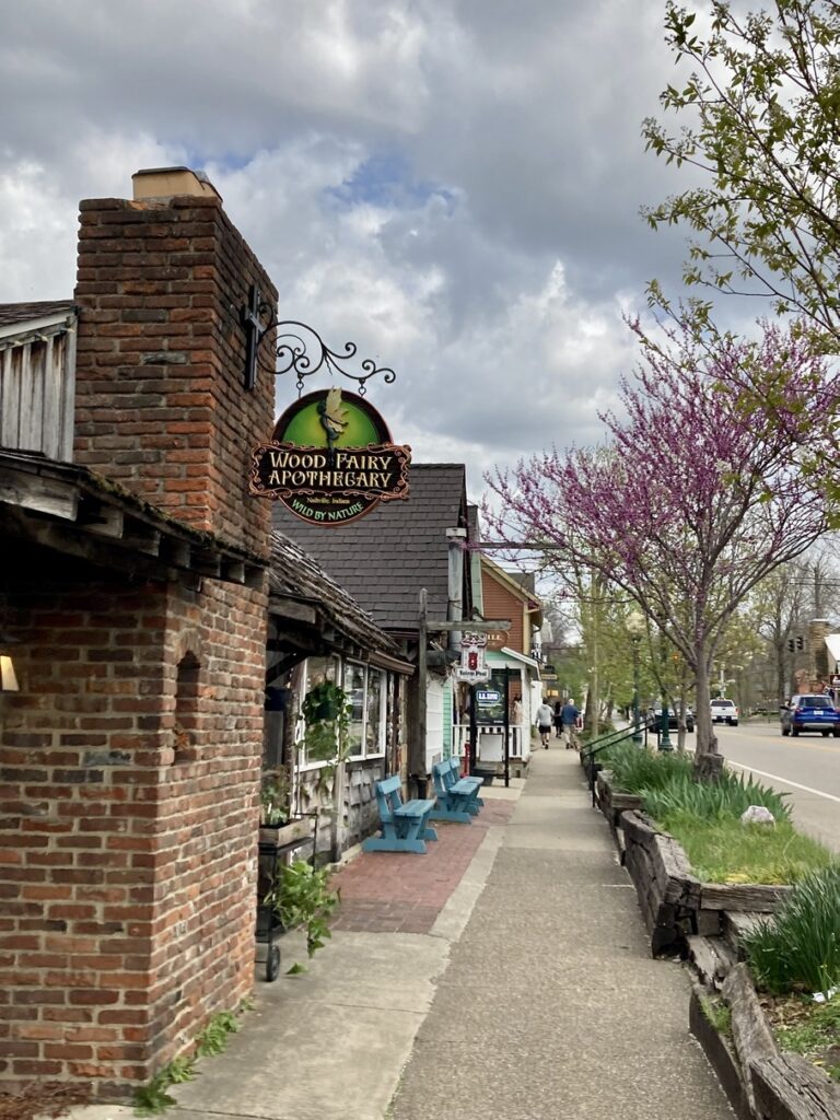 A photo down the sidewalk with small, brick shops on the left