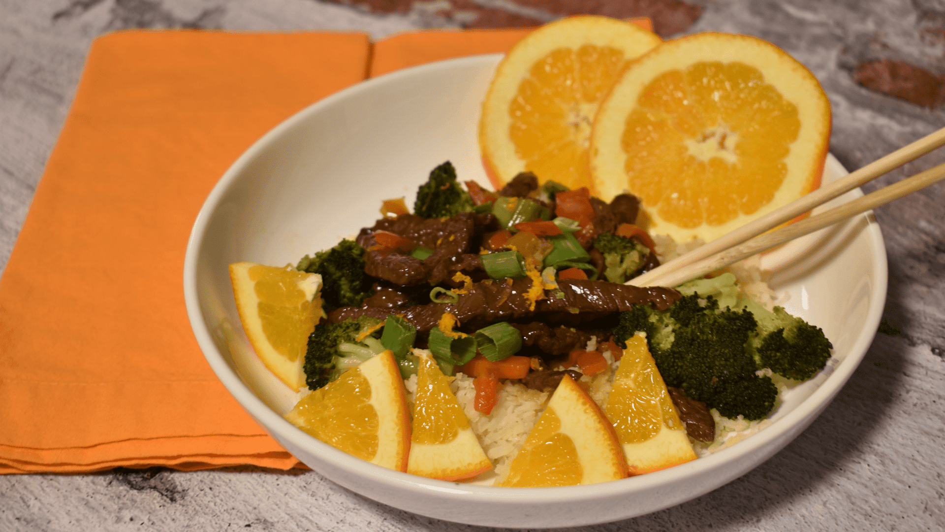A bowl with beef, carrots, red peppers, and broccoli