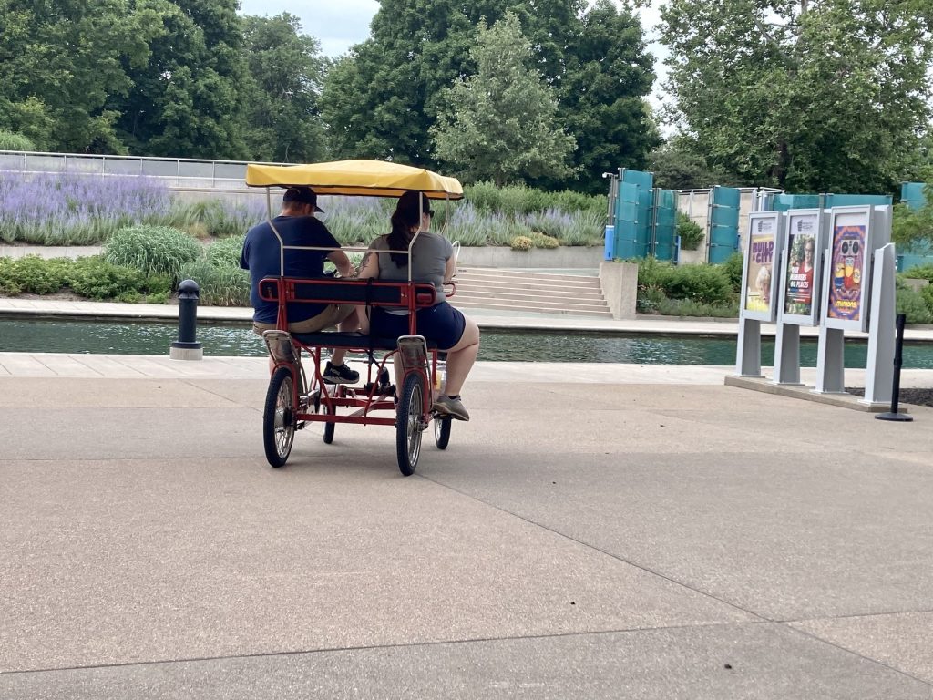 Two people on a surray riding by the canal 