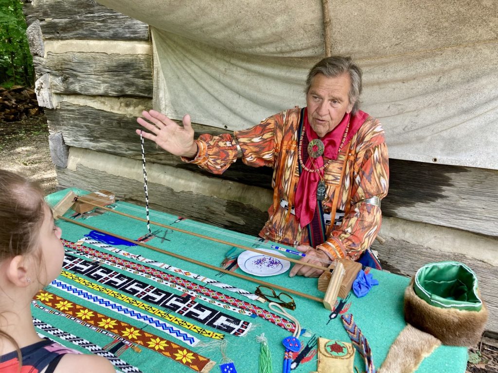 A Native American sharing glass bead work at Lenape Indian Camp at Conner Prairie
